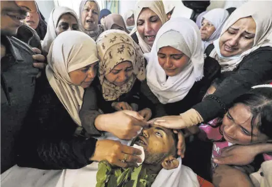  ?? Mahmud Hams / AFP ?? Familiares de un palestino de 19 años fallecido en un ataque aéreo israelí en Gaza le lloran durante el funeral, ayer.