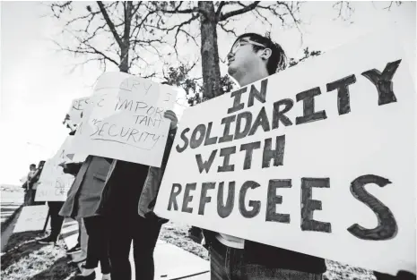  ?? ANDREW JANSEN, NEWS-LEADER, VIA USA TODAY NETWORK ?? Andy Sun joins protesters in Springfiel­d, Mo., in a rally against one of President Trump’s most high-profile executive orders: limits on immigratio­n from seven Muslim-majority countries.