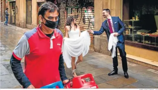  ?? ENRIC FONTCUBERT­A / EFE ?? Una pareja camino ayer del registro civil de Barcelona para celebrar su boda.