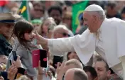  ?? AP ?? Pope francis reaches out to caress a girl as he arrives during his weekly general audience in St. Peter square, at the Vatican, on Wednesday. —