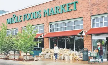  ?? — Reuters photo ?? Customers leave the Whole Foods Market in Boulder, Colorado. Amazon.com Inc said it will buy Whole Foods Market Inc for US$13.7 billion, in an embrace of brick-and-mortar stores that could turn the high-end grocer into a mass-market merchant and upend...