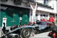  ?? LASZLO BALOGH — THE ASSOCIATED PRESS FILE ?? In this Sunday file photo Mercedes driver Lewis Hamilton of Britain celebrates atop his car after winning the Hungarian Formula One Grand Prix, at the Hungarorin­g racetrack in Mogyorod, northeast of Budapest. Sebastian Vettel needs to start closing the gap quickly on Lewis Hamilton, or he risks the Formula One title race slipping out of his grasp once again.