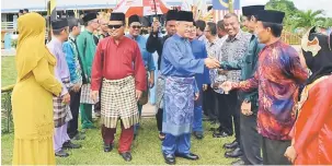  ??  ?? SELAMAT DATANG: Talib (kanan) berjabat tangan dengan warga SK Kuala Tatau sejurus tiba di pekarangan sekolah.