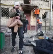  ?? ?? An injured man walks past a body of a man who was killed by a Russian strike in Kharkiv, Ukraine, Wednesday.