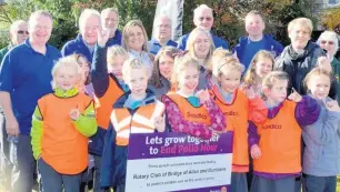  ??  ?? Flower power Rotarians with with children from Dunblane primary schools who have planted purple crocuses to publicise World Polio Day