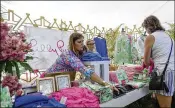  ?? ANDRES LEIVA / PALM BEACH POST ?? Chelsea Barry takes a call Saturday as she works the Lilly Pulitzer Lounge during the third round of the Honda Classic in Palm Beach Gardens.