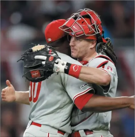  ?? ASSOCIATED PRESS FILE ?? Pitcher Hector Neris, left, and catcher J.T. Realmuto hug after a 2-0 victory over the Atlanta Braves on July 2. The Phillies will need more scenes like this in the second half to be a playoff team.