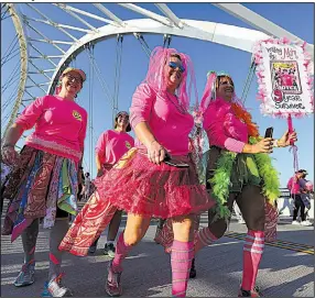  ?? Arkansas Democrat-Gazette/THOMAS METTHE ?? Decked out in pink, Elita Caple (from left), Carla Robertson and Tracy Gartska walk across the Broadway bridge during the 2017 Komen Arkansas Race for the Cure in Little Rock on Saturday. A full count was not available Saturday, but more than 16,000...