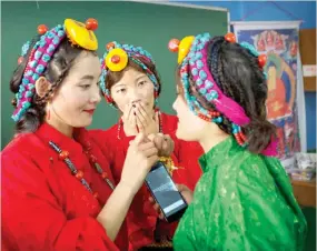  ??  ?? Exiled Tibetans women prepare for a dance performanc­e during celebratio­ns marking the 82nd birthday of the Dalai Lama in New Delhi on Thursday. (AP)