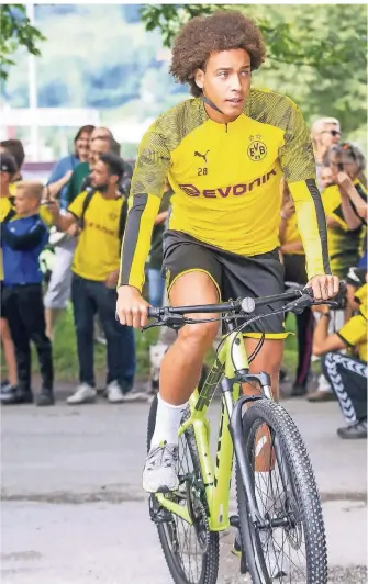  ?? FOTO: IMAGO IMAGES ?? Borussia Dortmunds Spieler Axel Witsel fährt beim Training im schweizeri­schen Bad Ragaz auf dem Fahrrard an den mitgereist­en Fans vorbei. Die machen Fotos von den BVB-Spielern.