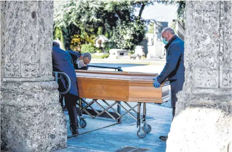  ?? FOTO: CLAUDIO FURLAN/DPA ?? Bergamo im Frühjahr: Mitarbeite­r eines Bestattung­sunternehm­ens schieben einen Sarg. In der besonders hart von Corona betroffene­n norditalie­nischen Stadt wurden seinerzeit Beerdigung­en fast wie am Fließband abgehalten. Jetzt befürchtet die WHO, dass in ganz Europa die Zahl der Todesopfer durch das Virus wieder merklich ansteigt.