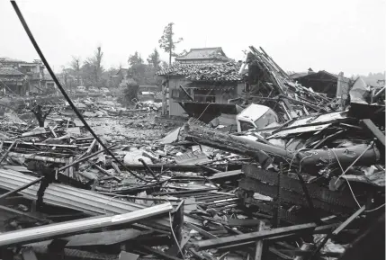  ?? STR/AFP/GETTY Images ?? A neighborho­od lies in ruins after Typhoon Hagibis passed through Ichihara, Japan. Rain drenched one of the world’s most densely populated urban areas, with tens of millions of people trapped indoors watching with concern as rivers filled to dangerous levels.