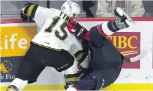  ??  ?? The London Knights Cole Tymkin checks Spitfires rookie Connor Corcoran into the boards during Game 3.