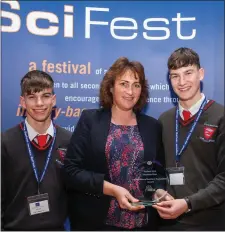  ??  ?? Mary Mullaghy from the Irish Science Teachers’ Associatio­n presents Conn Caomhánach and Con Ó’Meachair with their award.