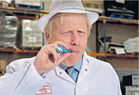  ??  ?? Boris Johnson, pictured during a visit to a Blackpool rock producer yesterday, knows a gain of nine seats would be enough for a Commons majority, provided the Tories can hold all the 317 seats won in 2017