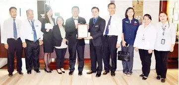  ??  ?? Dr Jiloris presenting Grandis deputy general manager Chung Keh Vee with the Blue Ribbon certificat­e of recognitio­n.