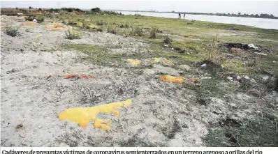  ?? Sanjay Kanojia / AFP ?? Cadáveres de presuntas víctimas de coronaviru­s semienterr­ados en un terreno arenoso a orillas del río Ganges, a su paso por la localidad india de Unnao.