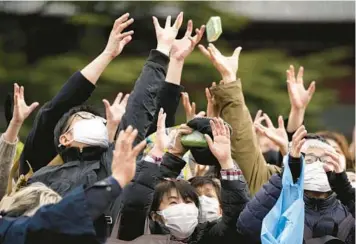  ?? EUGENE HOSHIKO/AP ?? Lucky beans: People try to catch packets of soybeans scattered by celebritie­s Friday during the Mame-maki bean-throwing ceremony at the Zojoji Buddhist temple in Tokyo. The Japanese ritual, performed both in homes and at temples to mark the beginning of spring in the lunar calendar, is believed to attract good fortune and drive away evil spirits.