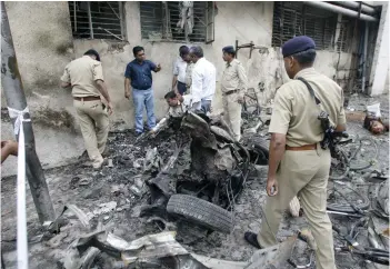  ?? — AFP file photo ?? Indian forensic experts collecting evidence from a blast site outside the Civil Hospital in Ahmedabad following a series of bombings the day before which killed dozens.