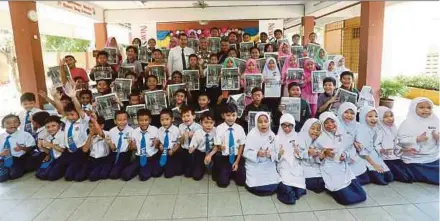  ?? PIC BY SALHANI IBRAHIM ?? ‘New Straits Times’ group editor Rashid Yusof with pupils after the launch of the NST Empowering English in Education School Sponsorshi­p Programme at SK Jalan Pasar 1, Kuala Lumpur, yesterday. With them are New Straits Times Press Bhd sales, production and distributi­on general manager Sazali Hashim and headmaster Kamarul Ariffin Ishak.