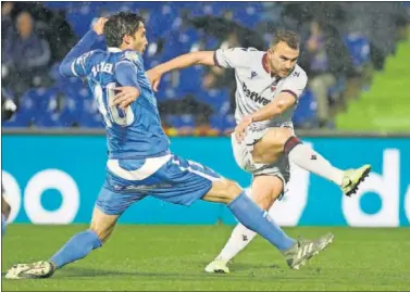  ??  ?? Borja Mayoral dispara a puerta ante la presencia de Etxeita en el último Levante-Getafe.