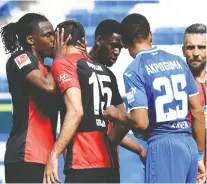  ?? THOMAS KIENZLE/VIA REUTERS ?? Hertha Berlin’s Dedryck Boyata embraces teammate Marko Grujic after Grujic scored in Saturday’s 3-0 win over Hoffenheim. The post-goal kiss was a clear flouting of the top soccer league’s physical distancing restrictio­ns as it returns to action during the pandemic.