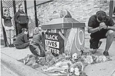  ?? ELIZABETH FLORES/STAR TRIBUNE ?? Mourners pray at a makeshift memorial Tuesday near where a man was taken into custody the night before in Minneapoli­s. The death drew comparison­s to the case of Eric Garner.