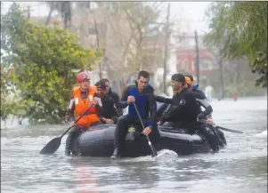  ?? AP PHOTO ?? Members of a rescue team navigate a flooded street in Havana after the passage of Hurricane Irma in Cuba on Sunday. The powerful storm ripped roofs off houses, collapsed buildings and flooded hundreds of miles of coastline after cutting a trail of...