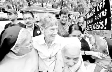  ??  ?? Fox (centre) is escorted by her colleagues before filing a petition calling for the review of her deportatio­n case at the Department of Justice. — Reuters photo