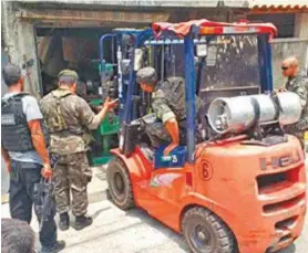  ?? Divulgação / Polícia civil ?? Policiais e militares retiram equipament­os da oficina de armeiro