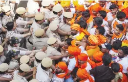  ?? — PTI ?? Security personnel attempt to stop devotees participat­ing in a ‘Hanuman Jayanti’ procession at Jahangirpu­ri in New Delhi on Tuesday.