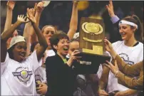  ?? The Associated Press ?? A REWARDING CAREER: Notre Dame coach Muffet McGraw, center, holds up the National Championsh­ip trophy on April 1, 2001, after Notre Dame defeated Purdue 68-66 for the NCAA Women’s Final Four Championsh­ip in St. Louis. At left is Imani Dunbar and Ruth Riley is at right. McGraw abruptly retired Wednesday, stepping down from Notre Dame, after a Hall of Fame coaching career that includes two national championsh­ips in 33 seasons.