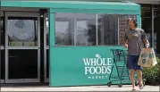  ?? NAM Y. HUH / ASSOCIATED PRESS ?? A shopper leaves a Whole Foods Market in Northbrook, Ill., on Saturday. Amazon is buying Whole Foods in a deal valued at about $13.7 billion, a strong move to expand its growing reach into groceries.