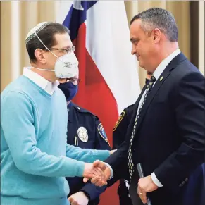  ?? Elias Valverde II / Associated Press ?? Rabbi Charlie Cytron-Walker of Congregati­on Beth Israel, left, shakes hands with Matthew J. DeSarno, Special Agent in Charge of the Dallas FBI Field Office, during a news conference Friday in Colleyvill­e, Texas.