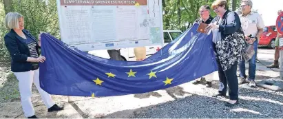  ?? RP-FOTO: KNAPPE ?? Monique de Boer, Kalle Wassong und Rianne Donders- de Leest zogen die Europaflag­ge von der ersten Info-Tafel und gaben den Wanderweg frei. Start ist auf dem Parkplatz am Lüsekamp.