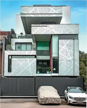  ?? ?? Conceptual­ised in geometric lines, these white-coated aluminium perforated panels lend the facade a serene look.