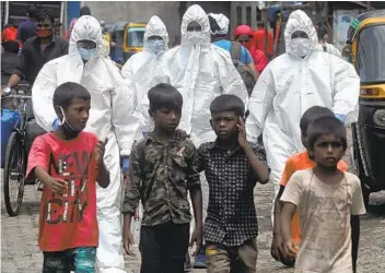  ?? RAFIQ MAQBOOL AP ?? Health workers arrive to screen people for COVID-19 symptoms at a slum in Mumbai, India, on Friday. India has overtaken Russia to become the third worst-affected nation by the coronaviru­s pandemic.