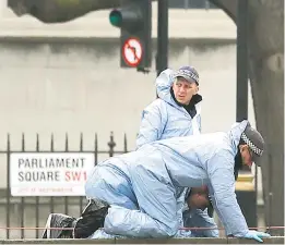  ??  ?? Forensic officers search the ground in Parliament Square, outside the Houses of Parliament, yesterday following the attack