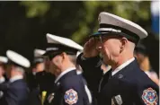  ?? Don Feria / Special to The Chronicle ?? SAN JOSE: Firefighte­r E.S. Dziuba salutes during the national anthem before the Patriot Day Procession.