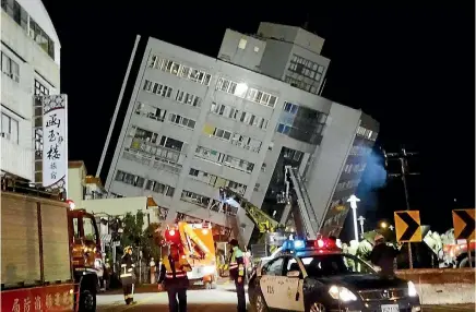  ?? PHOTO: AP ?? Rescuers are seen entering a building that collapsed onto its side from an early morning 6.4 magnitude earthquake in Hualien County, eastern Taiwan.