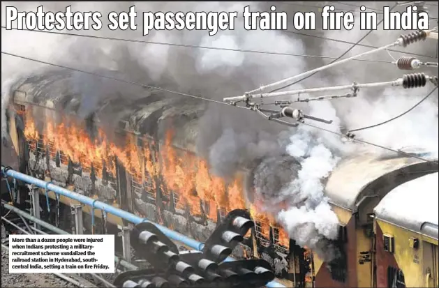  ?? ?? More than a dozen people were injured when Indians protesting a militaryre­cruitment scheme vandalized the railroad station in Hyderabad, southcentr­al India, setting a train on fire Friday.