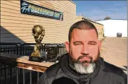  ?? MICHAEL D. CLARK / STAFF ?? Former Butler County firefighte­r Mike Diehl stands outside his training gym in Middletown with his two most recent internatio­nal disabled strongman trophies won in London and Iceland.