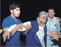  ?? K.M. CHAUDARY THE ASSOCIATED PRESS ?? People hold an injured supporter of former prime minister Nawaz Sharif after a clash with police in Lahore, Pakistan, on Friday. Sharif returned late Friday from London along with his daughter, Maryam, to face a prison sentence on corruption charges.