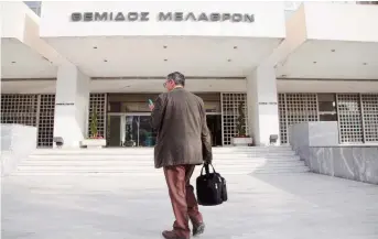  ??  ?? A man stands outside the Supreme Court in Athens yesterday. Judges’ unions hit out at the government for failing to restore their wages to 2012 levels despite court orders to do so. The government drafted legislatio­n this week in which it plans to...