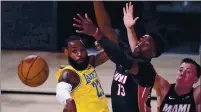  ?? MARK J. TERRILL — THE ASSOCIATED PRESS ?? The Lakers’ LeBron James (23) passes the ball while pressured by the Heat’s Bam Adebayo (13) during the second half of Game 1 of the NBA Finals on Wednesday in Lake Buena Vista, Fla.