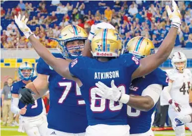  ?? CARL JUSTE/MIAMI HERALD ?? Tulsa’s Josh Atkinson lifts his arms as teammates celebrate his touchdown against Central Michigan on Monday.