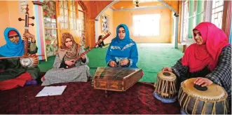  ??  ?? Kashmiri Muslim girls play instrument­s and sing Sufi music under the tutelage of music teacher, Muhammad Yaqoob Sheikh, on the outskirts of Srinagar.