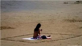  ??  ?? Una mujer en la playa de San Lorenzo, en Asturias, a finales de agosto.