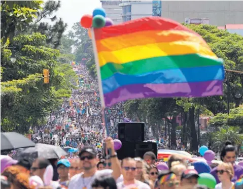  ?? JOHN DURÁN ?? Carrozas, disfraces, banderas, sombrillas y pancartas le dieron un tinte de carnaval al desfile, que reunió a miles en el corazón capitalino. La marcha multicolor en defensa de los derechos igualitari­os, salió del paseo Colón y finalizó en la plaza de...