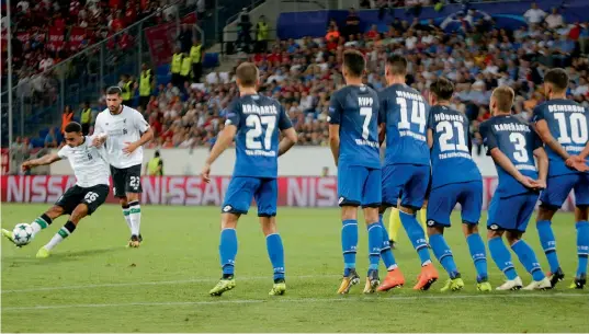  ??  ?? Liverpool’s Trent Alexander-Arnold (left) scores in their Champions League qualifier first leg match against 1899 Hoffenheim in Sinsheim on Tuesday. Liverpool won 2-1.